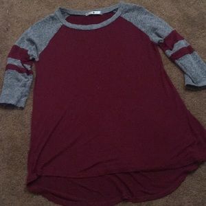 A maroon shirt with grey and red sleeves